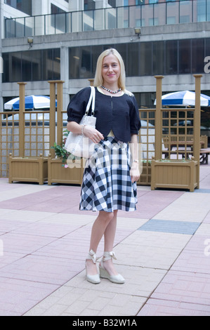 Schöne blonde Frau trägt einen aufgegebenen Rock Stockfoto