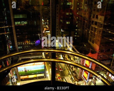 Blick von einer modernen Glaselevator bei Kowloons Nathan Road bei Nacht, Hongkong, China Stockfoto