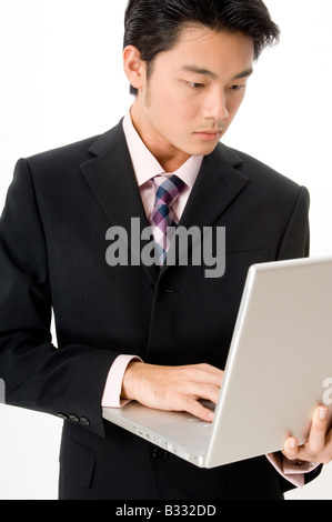 Eine intelligente asiatischen Geschäftsmann arbeitet an einem Laptop-computer Stockfoto
