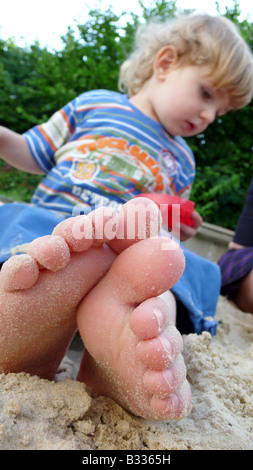 kleiner Junge in einem Sandkasten Stockfoto