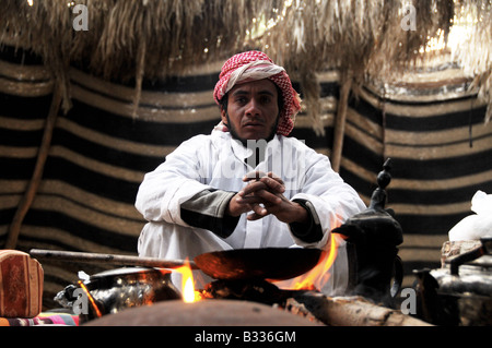 Ein traditioneller Beduinen Mann bereitet eine Mahlzeit in seinem großen Zelt in der Nähe von Dimona in der israelischen Negev-Wüste. Stockfoto