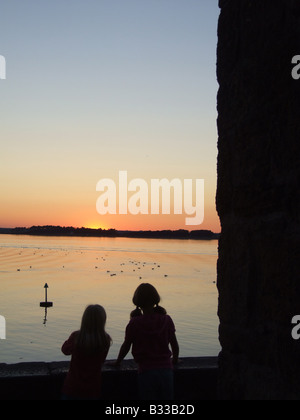 zwei Mädchen Blick auf das Rote Meer bei Sonnenuntergang zu beruhigen Stockfoto