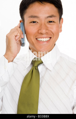 Glückliche junge asiatische Geschäftsmann halten eines Handys Stockfoto