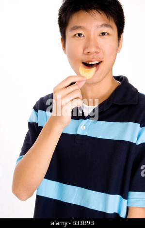 Ein junger asiatischer Mann genießt Essen chips Stockfoto
