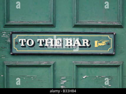 Pub Tür zeigt verwitterte Schild "Bar" mit gemalten Hand auf der rechten 1/2 Stockfoto