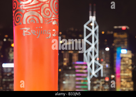 Replik der Olympischen Fackel für die Olympischen Spiele in Peking auf Kowloon Waterfront mit Bank Of China im Hintergrund, Hong Kong Stockfoto