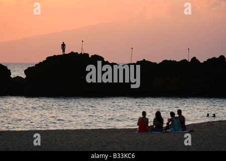 Touristen sehen einen Taucher von den schwarzen Felsen am Kaanapali Beach im Sheraton Maui Resort in Maui, Hawaii Stockfoto