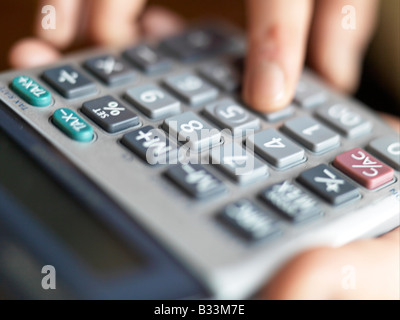 Eine Nahaufnahme der weiblichen Hände, die Verwendung eines Taschenrechners Stockfoto