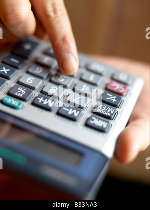 Eine Nahaufnahme der weiblichen Hände, die Verwendung eines Taschenrechners Stockfoto