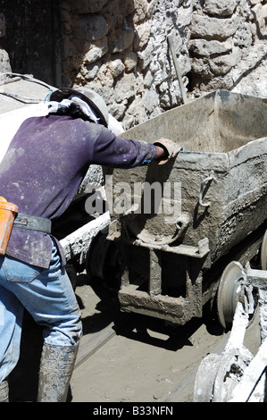 Bergmann Druck einen leeren Wagen außerhalb einer Mine Bolivien Südamerika Stockfoto