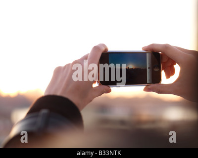 Eine junge Chinesin nutzt ihr Handy, um ein Foto aufzunehmen. Stockfoto