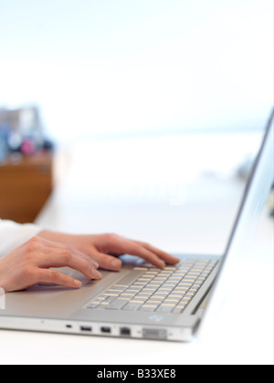 Die Hand einer Frau auf einem Laptop tippen. Stockfoto