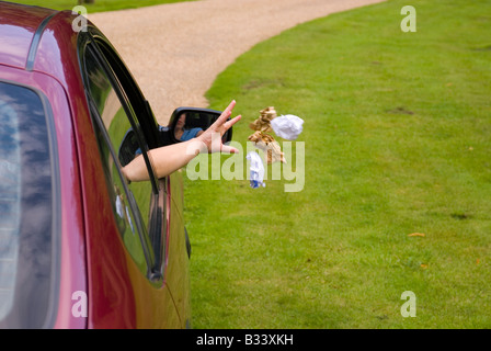 Person werfen Müll aus Autofenster Stockfoto