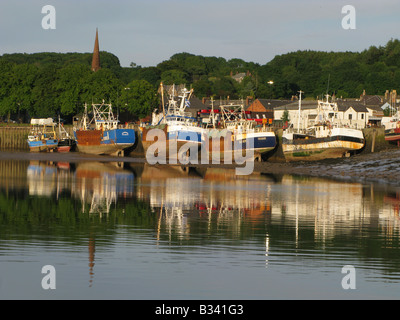 Geringe Wasser in Kirkcudbright Hafen mit der Jakobsmuschel Boote gefesselt Neben der Hafenmauer Stockfoto