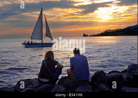 Segelboot am Lac Leman bei Sonnenuntergang mit einem jungen Paar Silouetted, Montreux, Waadt Schweiz Stockfoto