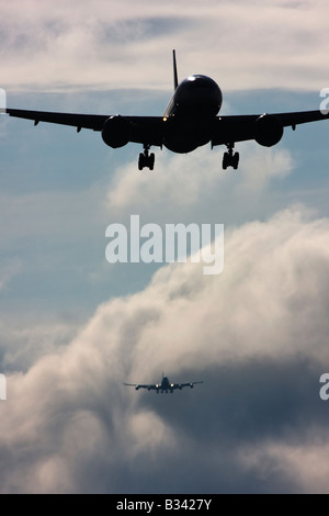 Wecken Sie Turbulenz Formen hinter Flugzeugen als sie Pässe durch die Wolken beim Abstieg zur Landung. Flughafen London Heathrow UK Stockfoto