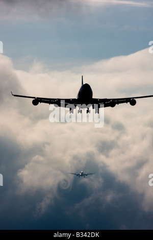 Wecken Sie Turbulenz Formen hinter Flugzeugen als sie Pässe durch die Wolken beim Abstieg zur Landung. Flughafen London Heathrow UK Stockfoto