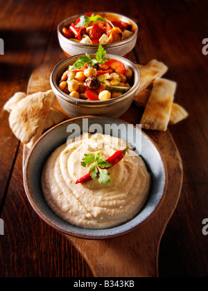 Party Food - von vorne - Houmous, [Kichererbse] Salat, marinierte mediterrane gebratene Paprika Stockfoto