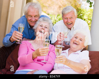 Zwei Paare auf der Terrasse trinken Champagner und lächelnd Stockfoto