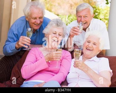 Zwei Paare auf der Terrasse trinken Champagner und lächelnd Stockfoto