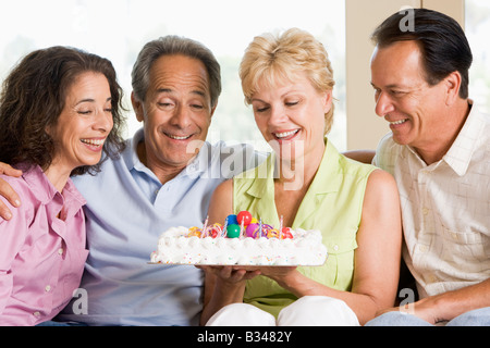 Zwei Paare im Wohnzimmer mit Kuchen lächelnd Stockfoto