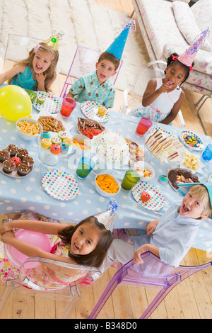 Kleinkinder auf Party mit Lächeln auf den Lippen Essen am Tisch sitzen Stockfoto