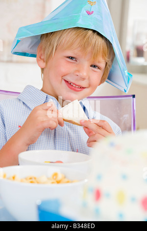 Junge Party mit einem Sandwich lächelnd am Tisch sitzen Stockfoto