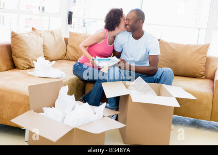 In der neuen Heimat küssen und lächelnd Boxen paar Auspacken Stockfoto