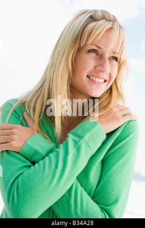 Blonde Frau in einem grünen Pullover posiert im freien Stockfoto
