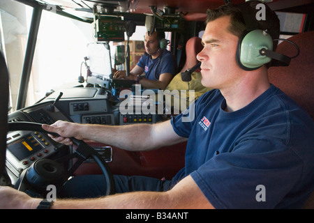 Zwei Feuerwehrleute im Feuerwehrauto Stockfoto