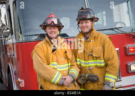 Zwei Feuerwehrmänner vor Feuerwehrauto Stockfoto