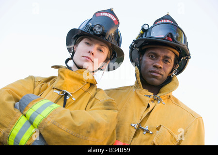 Zwei Feuerwehrleute stehen im Freien mit Helmen Stockfoto