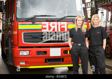 Zwei Feuerwehrleute stehen vor Feuerwehrauto Stockfoto