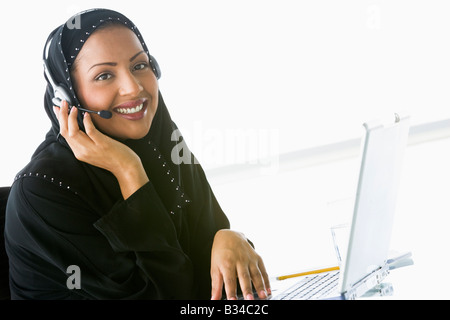 Frau trägt Kopfhörer mit Laptop lächelnd (hohe Schlüssel/selektiven Fokus) Stockfoto