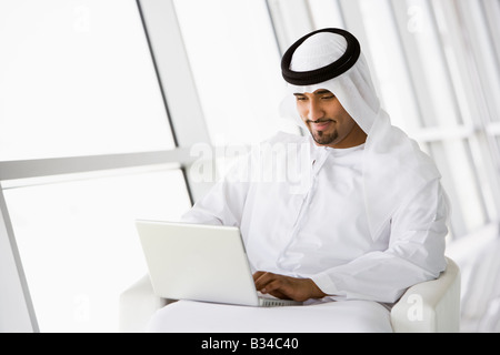 Mann im Innenbereich mit Laptop lächelnd (hohe Schlüssel/selektiven Fokus) Stockfoto