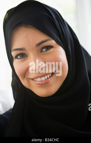 Frau stehend im Innenbereich lächelnd (high-Key) Stockfoto
