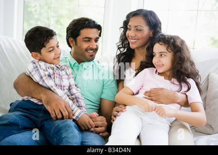 Familie im Wohnzimmer sitzend auf Sofa lächelnd (high-Key) Stockfoto