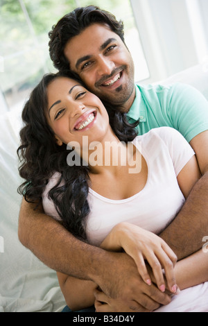 Paar im Wohnzimmer umarmen und lächelnd (high-Key) Stockfoto
