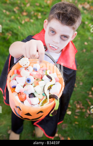 Kleiner Junge im Freien in Vampir Kostüm an Halloween Süßigkeiten halten Stockfoto