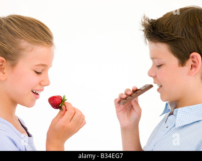 Schwester Erdbeere von Bruder Schokoriegel essen Essen Stockfoto