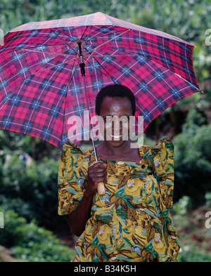 Uganda, Kampala, Lugazi. Eine BaGandan Frau im bunten Gewand. Die traditionellen knöchellangen Baumwolle Kleider getragen von BaGandan Frauen mit erhöhten, plissierte Ärmel genäht sind, verleiht dem Kostüm eine geflügelte Wirkung. Oben auf dem Kleid oder eine Bluse ist in einem breiten Gürtel um eine baggy Wirkung um die Taille geben oft versteckt. Der ungewöhnliche Stil wird geglaubt, um von den viktorianischen Kleidern getragen von Frauen des 19. Jahrhunderts Missionare nach Uganda angepasst wurden. Stockfoto