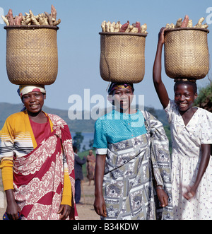 Uganda, Kisoro, Lake Mutanda. Eine Gruppe von fröhlichen Frauen tragen süße Kartoffeln auf den Markt in traditionelle Split-Bambus Körbe auf dem Kopf balanciert. Stockfoto