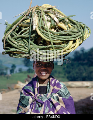 Uganda, Kisoro, Lake Mutanda. Ein junges Mädchen trägt Spulen der grünen "Rope" auf den Markt, auf dem Kopf balanciert. Stockfoto