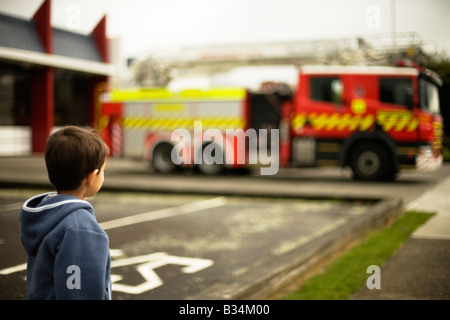 Sechs Jahre alter Junge schaut Feuerwehrauto außerhalb Feuerwache in Palmerston North New Zealand Stockfoto