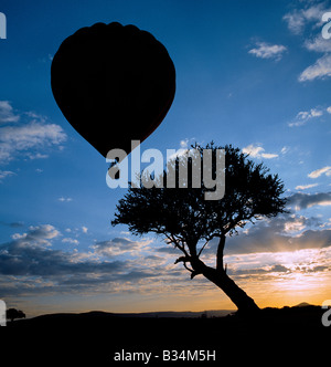 Kenia, Narok District, Masai Mara. Ein Heißluftballon startet in Masai Mara Game Reserve beim Sonnenaufgang über entfernten Hügel. Stockfoto