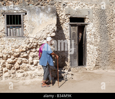 Kenia, Insel Pate Pate Dorf. Ein Swahili-Mann geht zum Eingang seines Hauses in Pate Dorf. Alle Gebäude im Pate ar Stockfoto