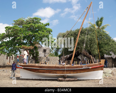 Kenia, Küstenprovinz, Lamu Insel. Bootsbauer Schliff den letzten zu einer neuen Jahazi in der offenen Werft am Matondoni, Insel Lamu. Der Ort ist bekannt für traditionelle hölzerne Segelboote für ein Jahrhundert oder mehr zu machen gewesen. Dhau oder Dau ist das umgangssprachliche Wort für den hölzernen Segelschiffen von der ostafrikanischen Küste von den meisten Besuchern benutzt, obwohl in Wirklichkeit eine Dhau ist ein viel größeres Hochsee-Gefäß als entweder das Medium Jahazi oder kleinere Mashua Angelboote/Fischerboote, die häufig auf Lamu zu sehen sind. Stockfoto