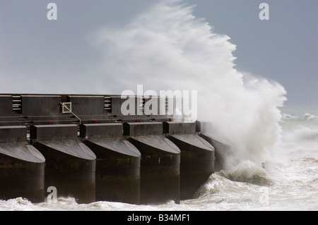 Stürmischer See und eine große Welle krachte gegen eine Betonwand Meer bei starkem Wind. Stockfoto