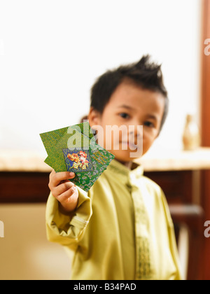 Malaiischen Boy zeigt zwei grünen Paket Stockfoto