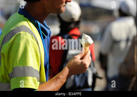 Ein Mitarbeiter des Eastbourne council läuft während einer Snack-Pause mit einem Eis. Bild von Jim Holden Stockfoto